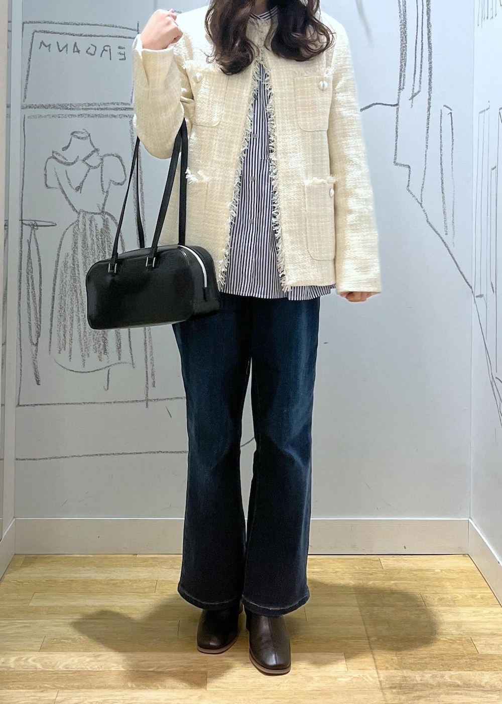 ブルー系のデニムパンツ、ブラック系のブーツ、ブラック系のボストンバッグを着用したレディースの冬コーディネートの5枚目の写真