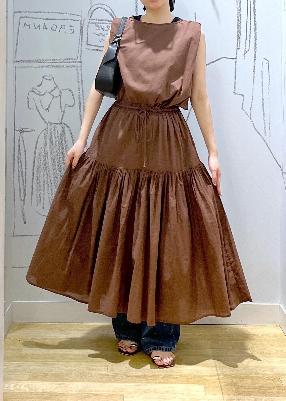 ブラック系のハンドバッグ、ブルー系のデニムパンツ、ブラウン系のサンダルを着用したレディースの夏コーディネートの8枚目の写真