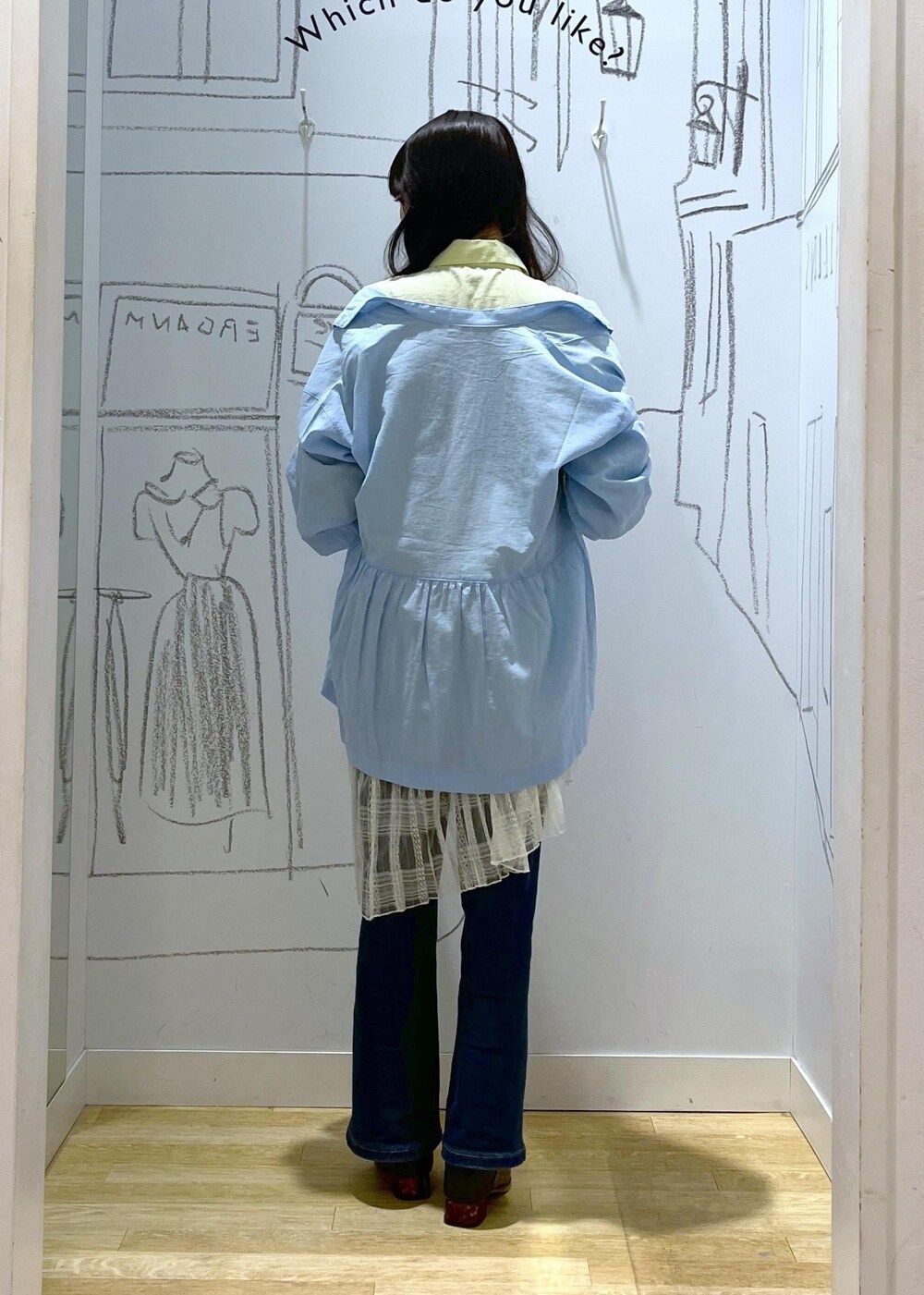 ブルー系のデニムパンツ、ブラック系のパンプス、ホワイト系のスカートを着用したレディースの春コーディネートの4枚目の写真