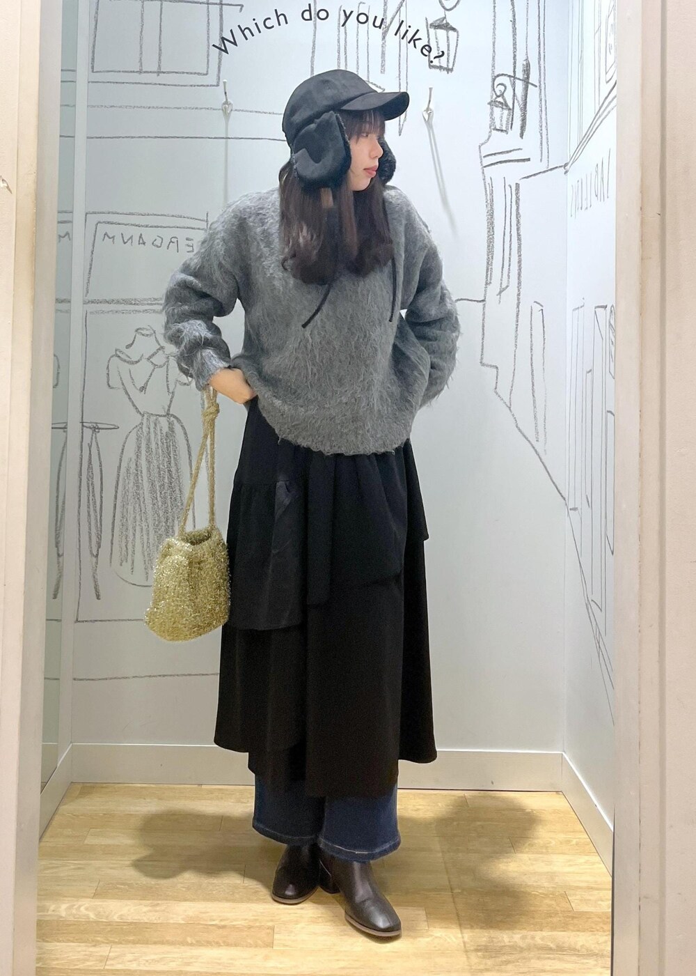 ブルー系のデニムパンツ、ブラック系のブーツ、ブラック系のスカートを着用したレディースの冬コーディネートの7枚目の写真