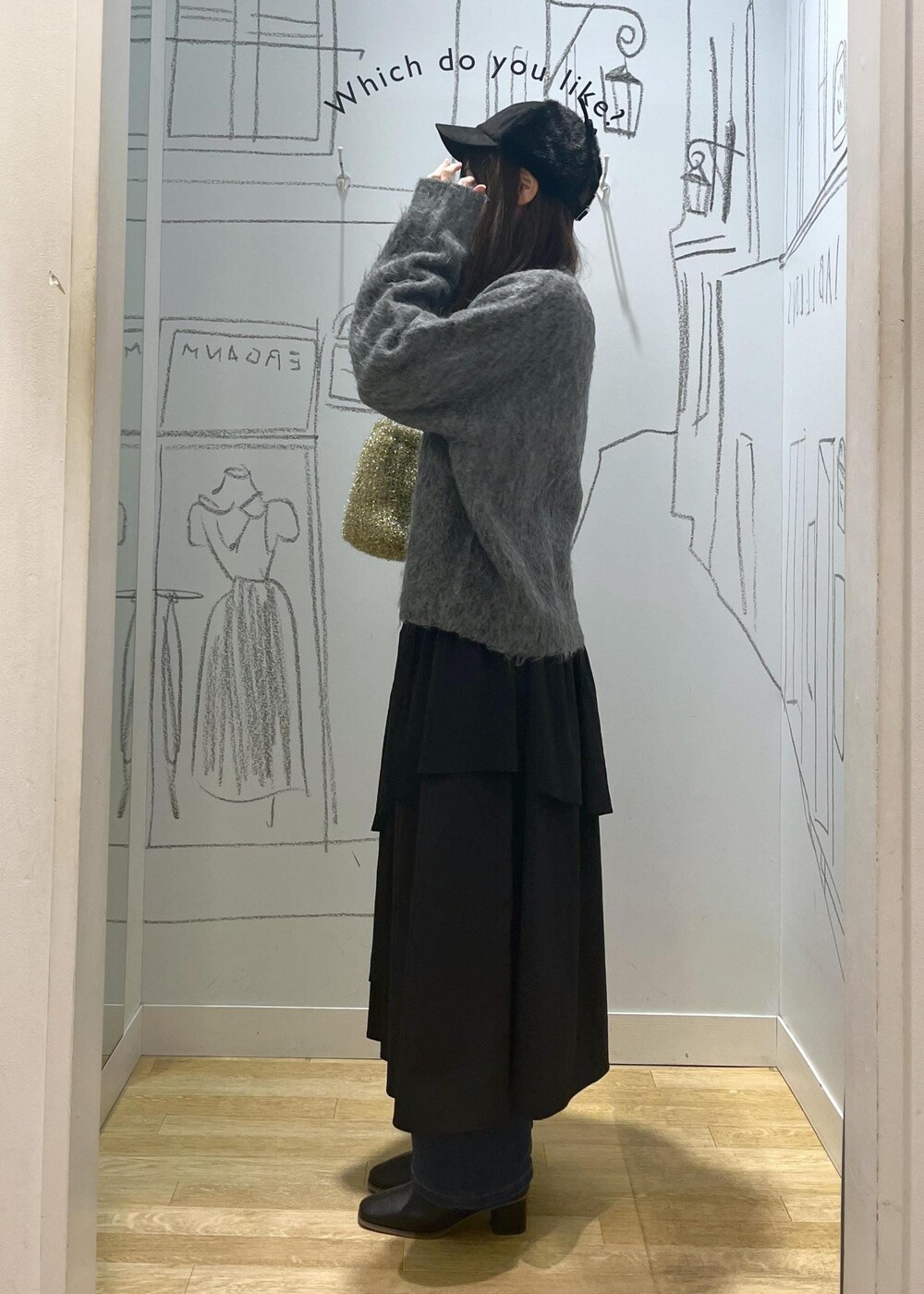 ブルー系のデニムパンツ、ブラック系のブーツ、ブラック系のスカートを着用したレディースの冬コーディネートの2枚目の写真