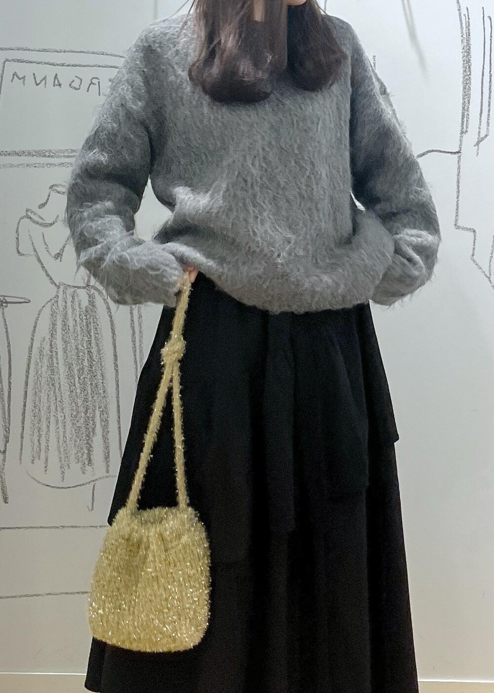 ブルー系のデニムパンツ、ブラック系のブーツ、ブラック系のスカートを着用したレディースの冬コーディネートの5枚目の写真