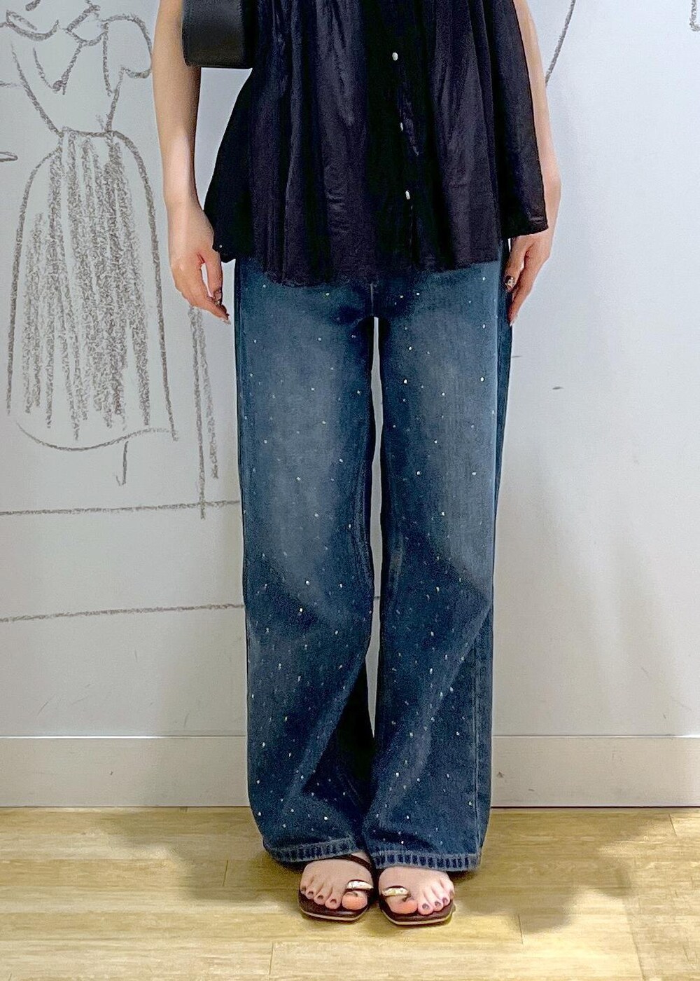 ブラック系のハンドバッグ、ブルー系のデニムパンツ、ブラウン系のサンダルを着用したレディースの夏コーディネートの7枚目の写真