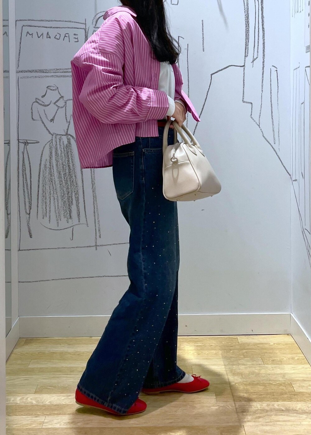 ブルー系のデニムパンツ、ベージュ系のボストンバッグ、ピンク系のシャツ/ブラウスを着用したレディースの春コーディネートの5枚目の写真