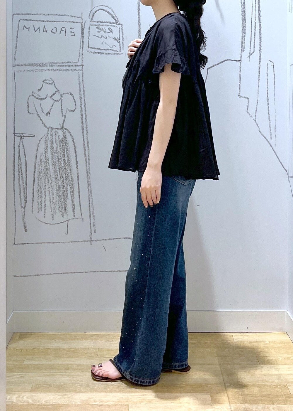 ブラック系のハンドバッグ、ブルー系のデニムパンツ、ブラウン系のサンダルを着用したレディースの夏コーディネートの5枚目の写真