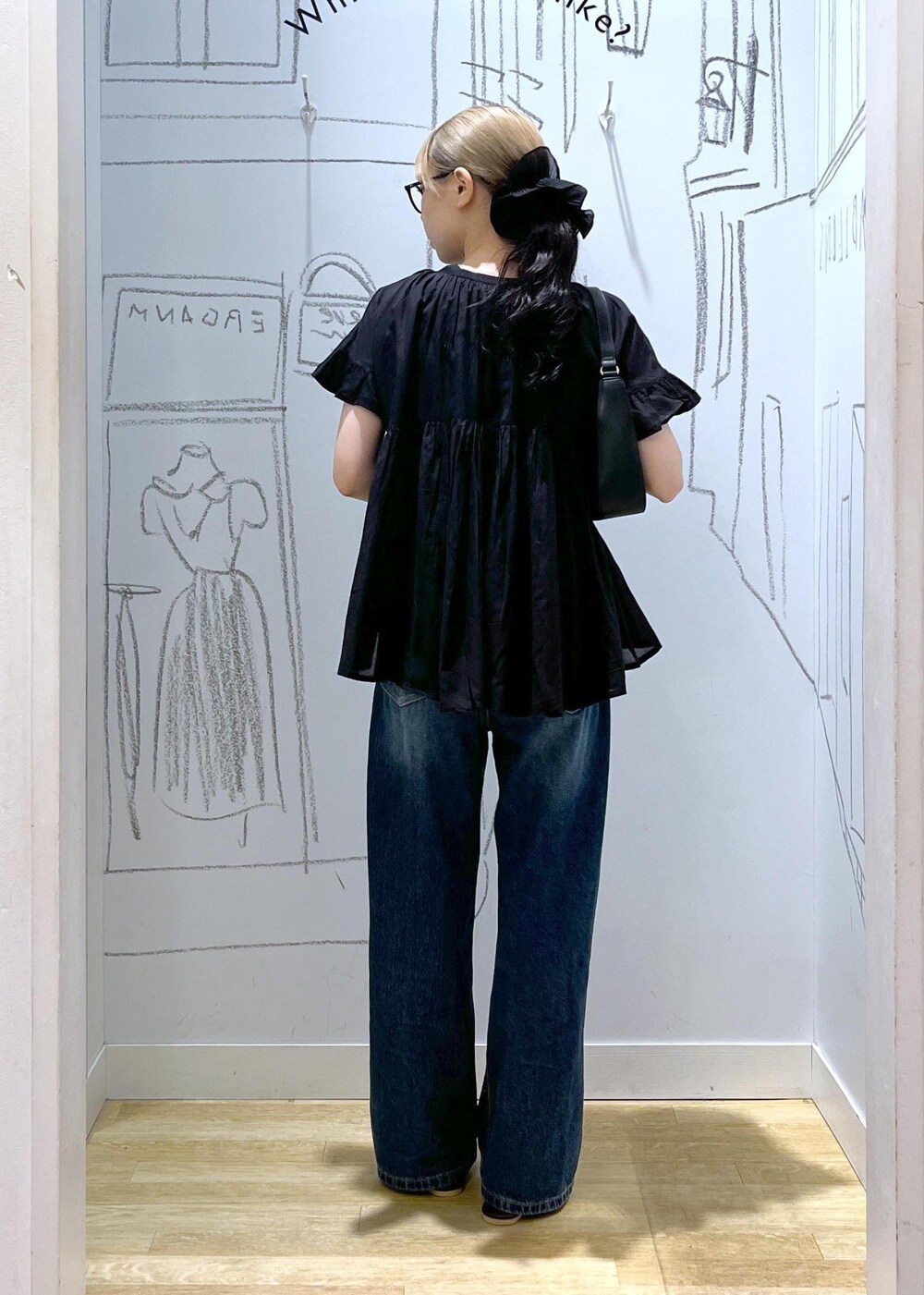 ブラック系のハンドバッグ、ブルー系のデニムパンツ、ブラウン系のサンダルを着用したレディースの夏コーディネートの4枚目の写真