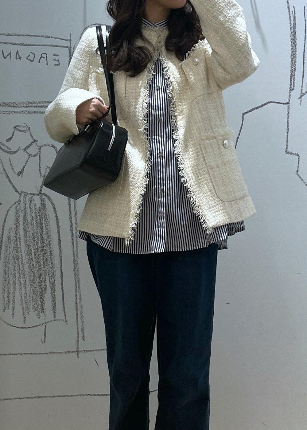 ブルー系のデニムパンツ、ブラック系のブーツ、ブラック系のボストンバッグを着用したレディースの冬コーディネートの4枚目の写真