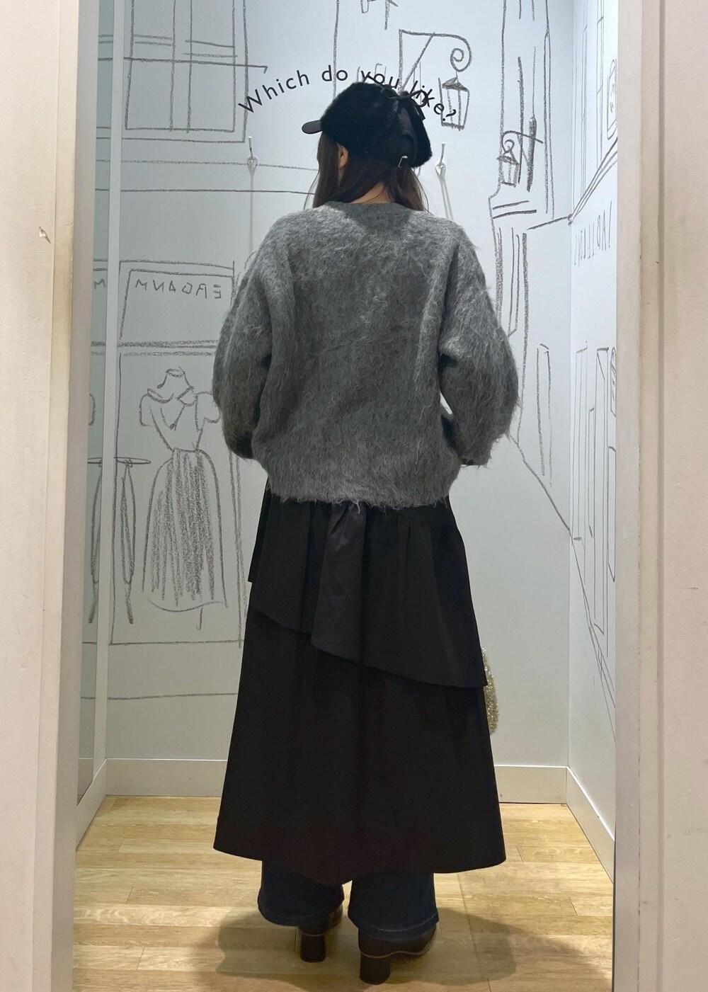 ブルー系のデニムパンツ、ブラック系のブーツ、ブラック系のスカートを着用したレディースの冬コーディネートの3枚目の写真