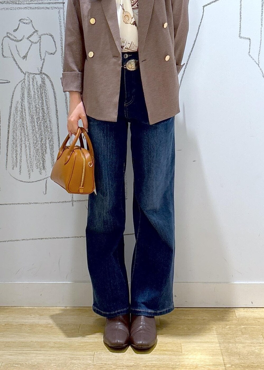 ブルー系のデニムパンツ、ベージュ系のテーラードジャケット、イエロー系のショルダーバッグを着用したレディースの秋コーディネートの7枚目の写真