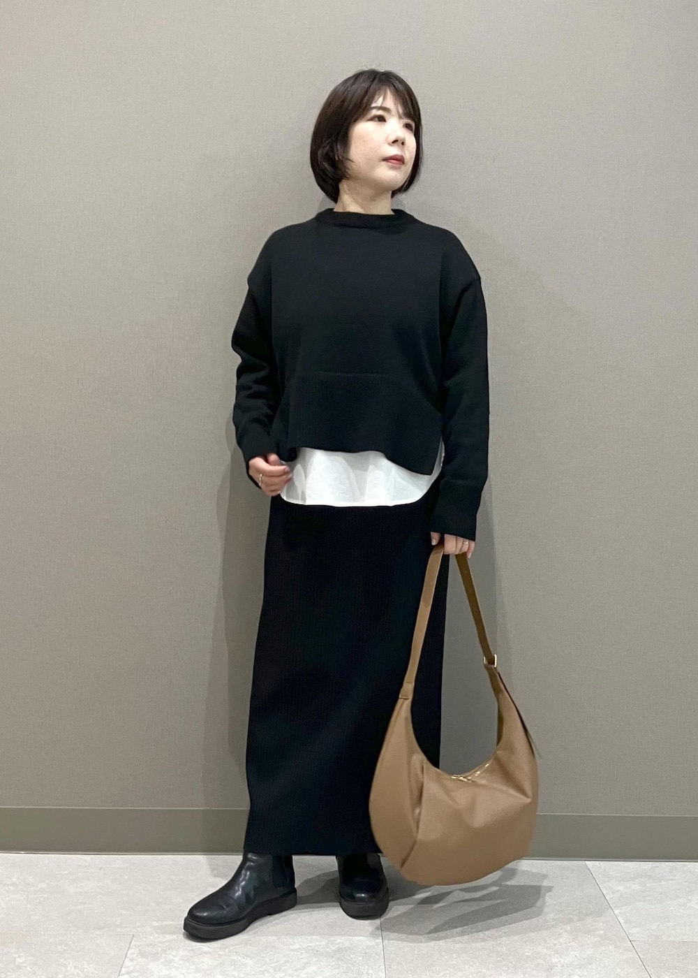 ブラック系のニット/セーター、ブラック系のスカート、ブラック系のダウンジャケット/コートを着用したレディースの冬コーディネートの7枚目の写真