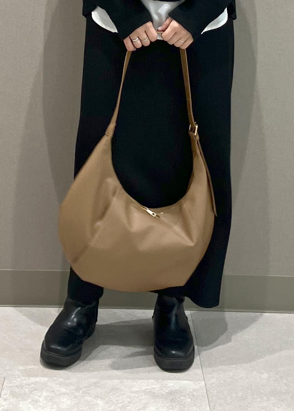 ブラック系のニット/セーター、ブラック系のスカート、ブラック系のダウンジャケット/コートを着用したレディースの冬コーディネートの9枚目の写真