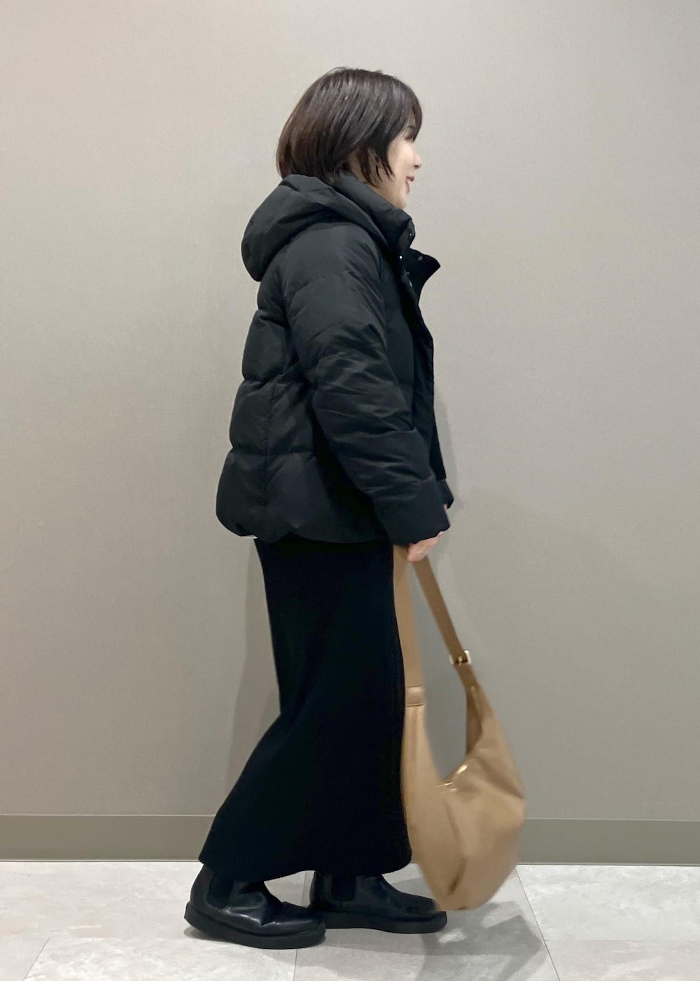 ブラック系のニット/セーター、ブラック系のスカート、ブラック系のダウンジャケット/コートを着用したレディースの冬コーディネートの4枚目の写真