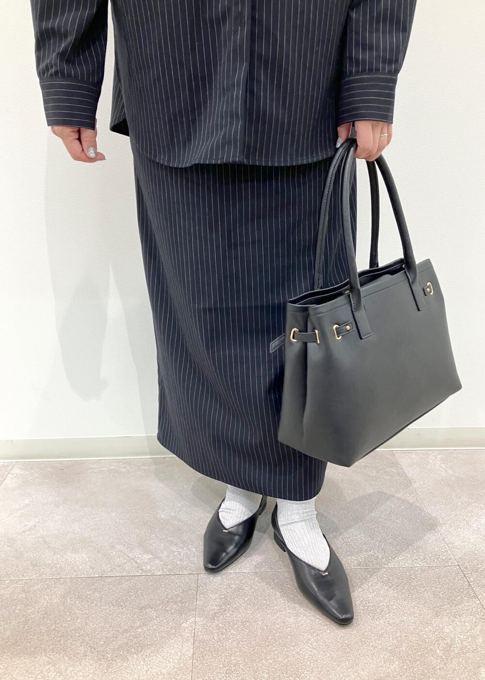 ブラック系のトートバッグ、ブルー系のワンピース、ブラック系のパンプスを着用したレディースの秋コーディネートの10枚目の写真