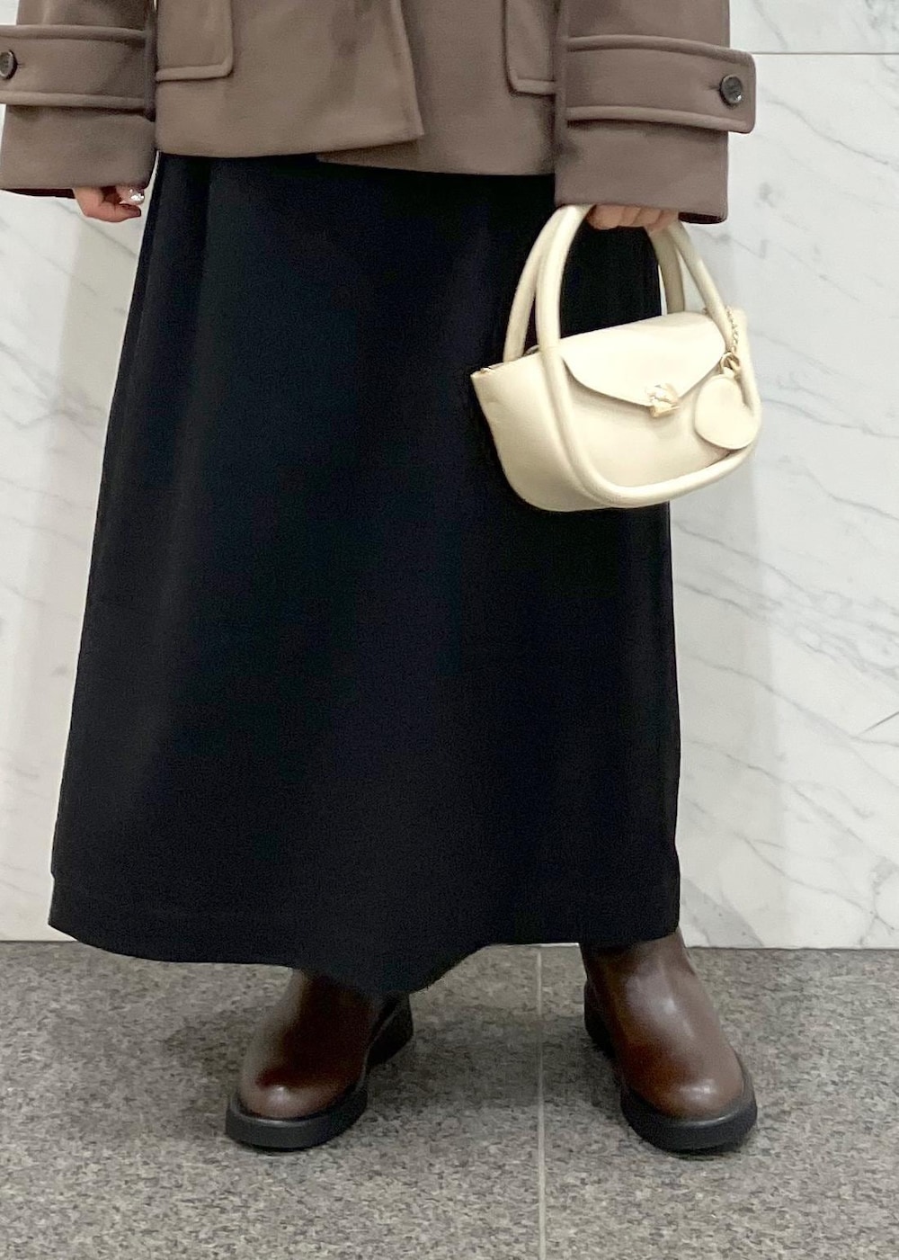 ブラック系のワンピース、ブラウン系のダッフルコート、ホワイト系のニット/セーターを着用したレディースの冬コーディネートの6枚目の写真