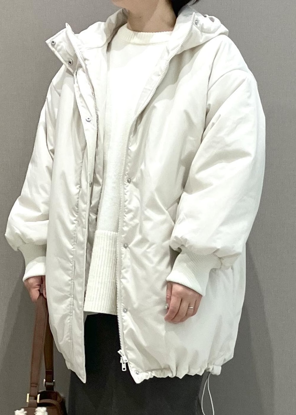 ホワイト系のニット/セーター、ブラウン系のショルダーバッグ、ブラウン系のスカートを着用したレディースの秋コーディネートの7枚目の写真