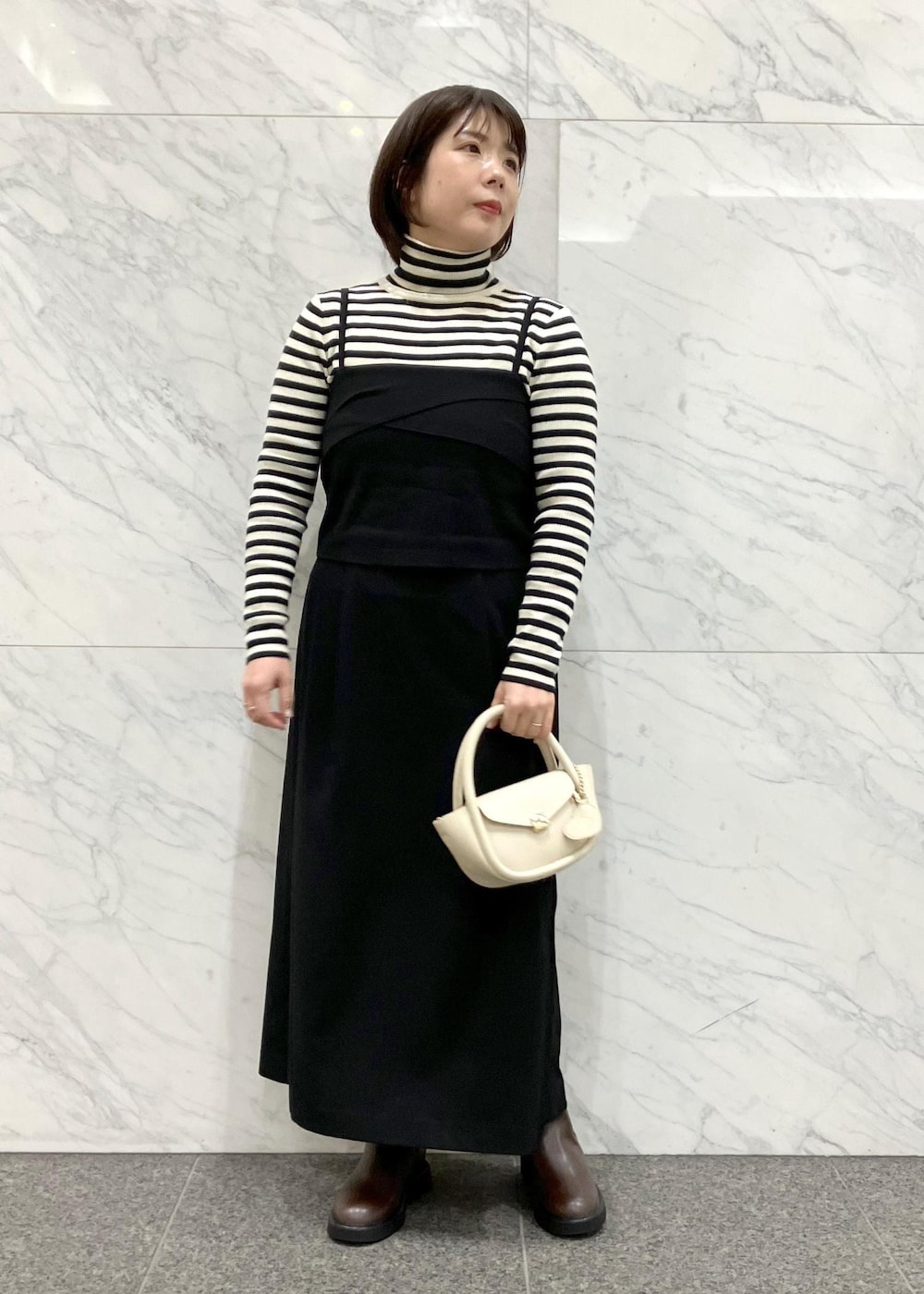 ブラック系のワンピース、ブラウン系のダッフルコート、ホワイト系のニット/セーターを着用したレディースの冬コーディネートの8枚目の写真