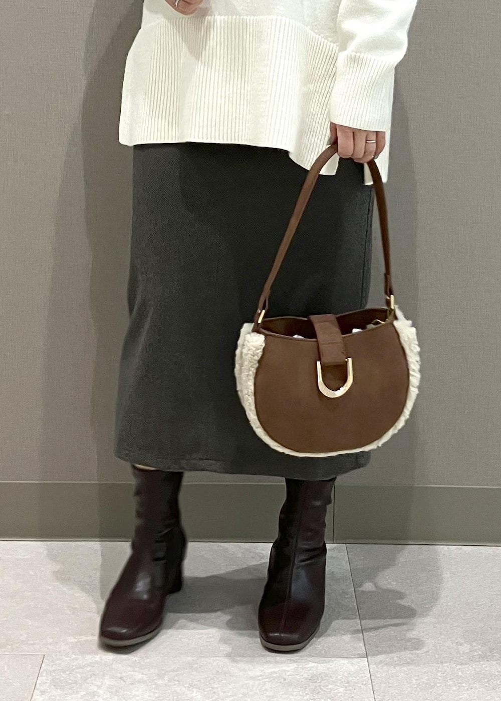 ホワイト系のニット/セーター、ブラウン系のショルダーバッグ、ブラウン系のスカートを着用したレディースの秋コーディネートの9枚目の写真