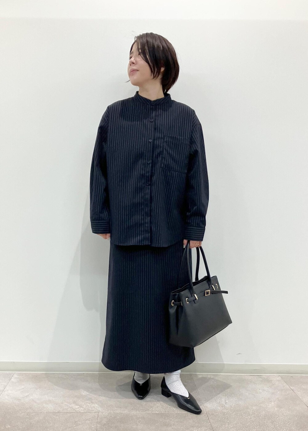 ブラック系のトートバッグ、ブルー系のワンピース、ブラック系のパンプスを着用したレディースの秋コーディネートの9枚目の写真