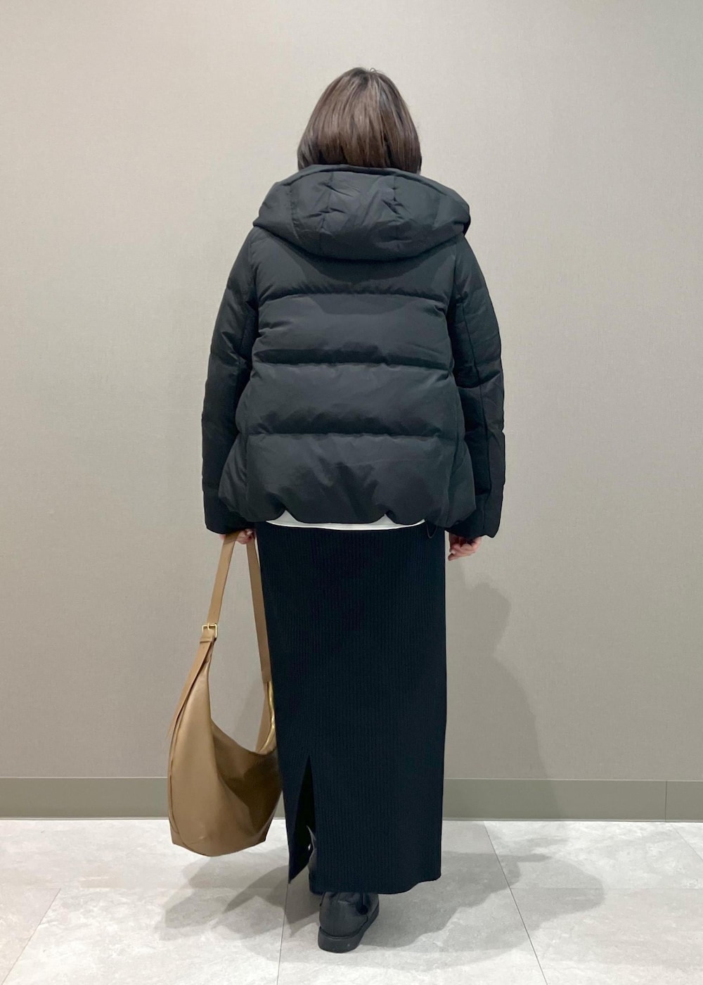 ブラック系のニット/セーター、ブラック系のスカート、ブラック系のダウンジャケット/コートを着用したレディースの冬コーディネートの5枚目の写真