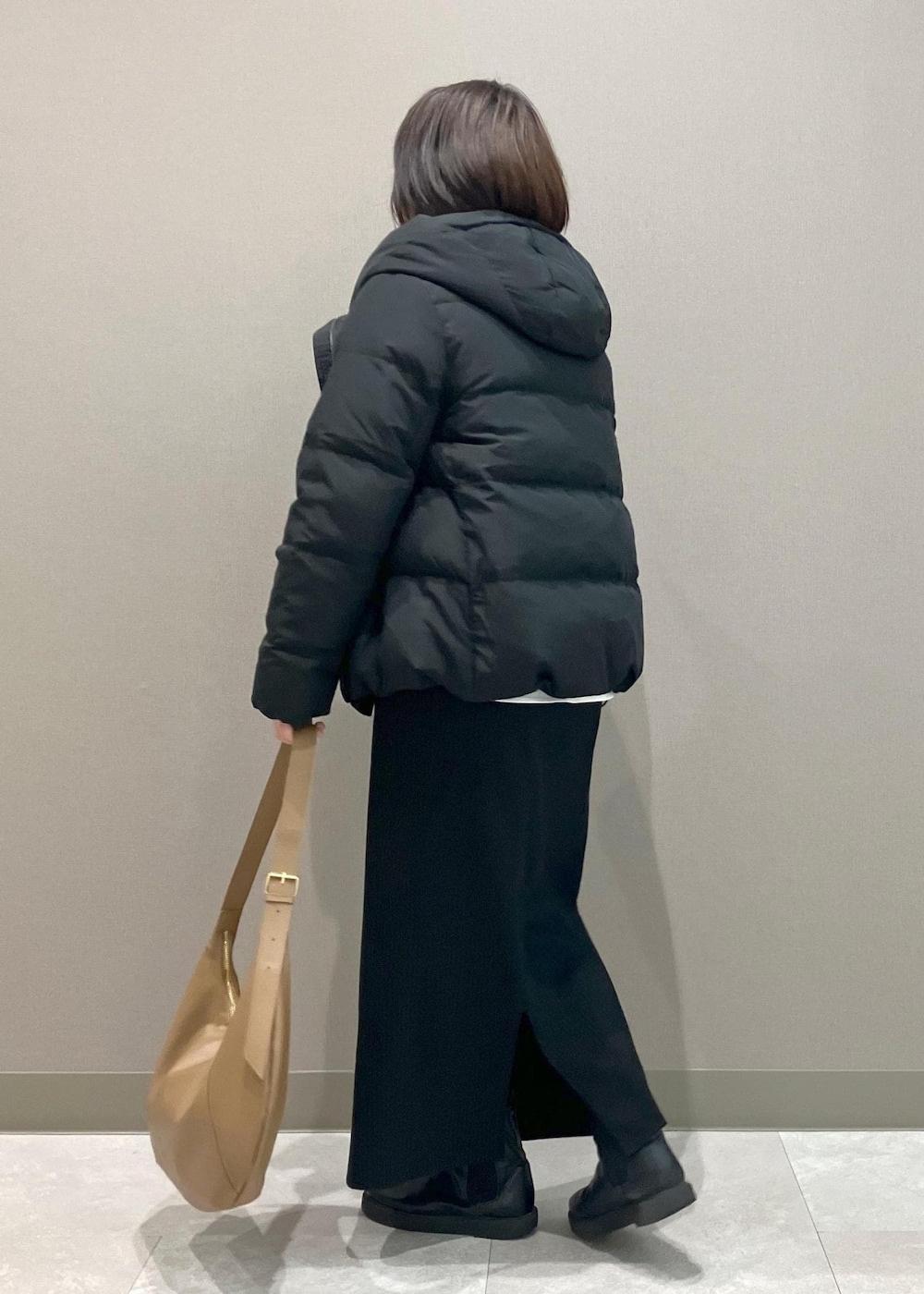 ブラック系のニット/セーター、ブラック系のスカート、ブラック系のダウンジャケット/コートを着用したレディースの冬コーディネートの3枚目の写真