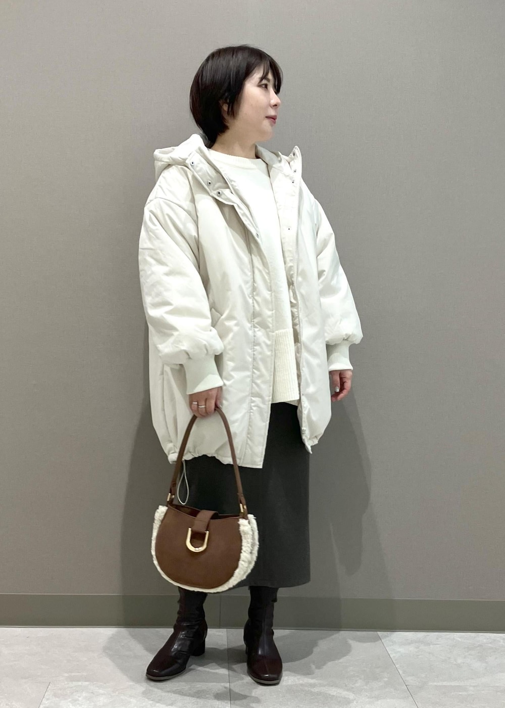 ホワイト系のニット/セーター、ブラウン系のショルダーバッグ、ブラウン系のスカートを着用したレディースの秋コーディネートの6枚目の写真