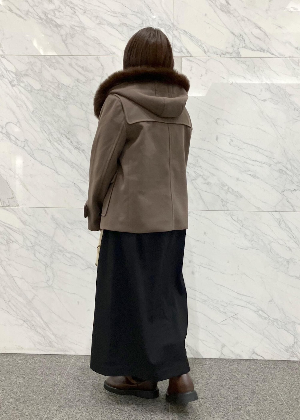 ブラック系のワンピース、ブラウン系のダッフルコート、ホワイト系のニット/セーターを着用したレディースの冬コーディネートの3枚目の写真