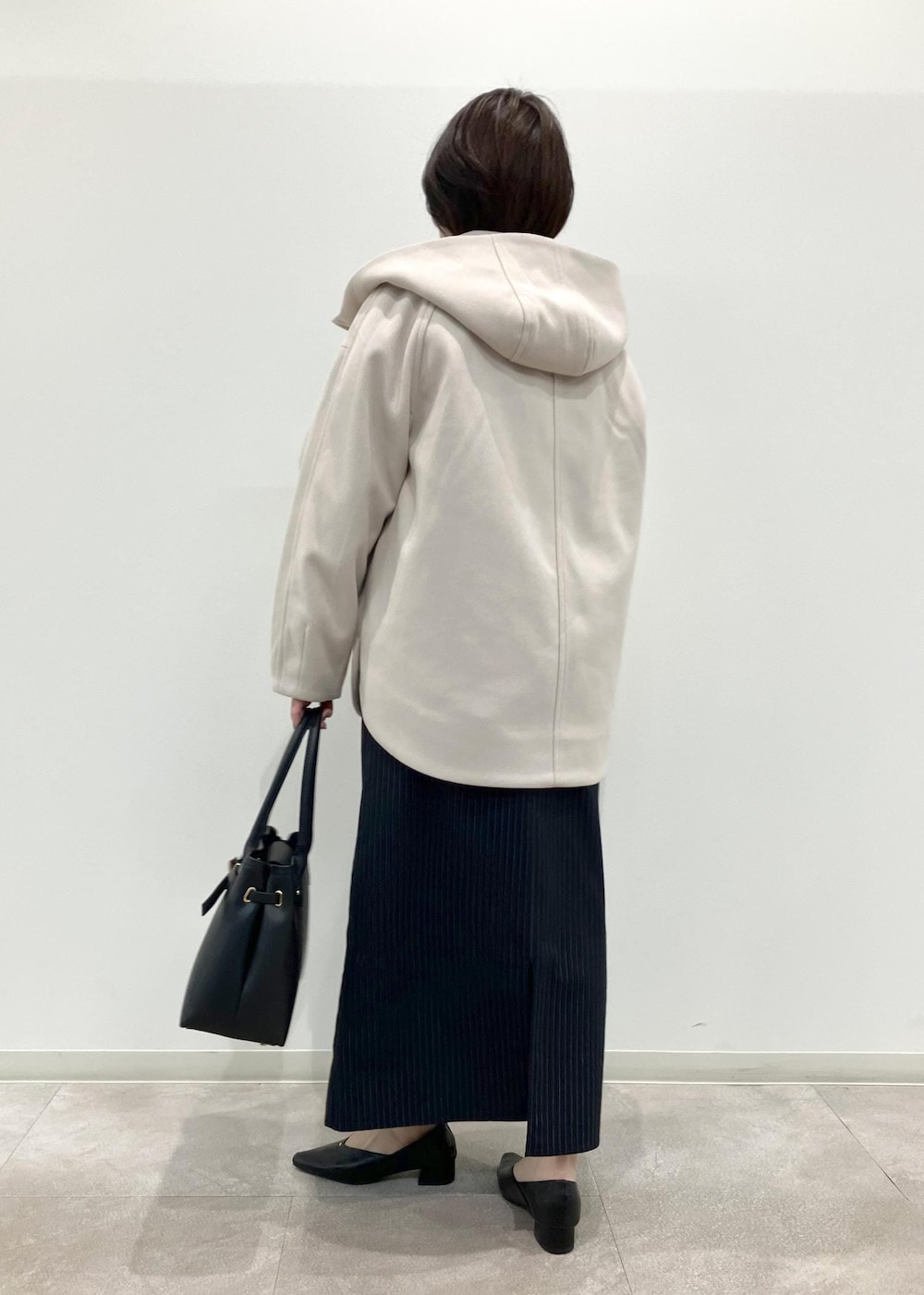 ブラック系のトートバッグ、ブルー系のワンピース、ブラック系のパンプスを着用したレディースの秋コーディネートの2枚目の写真