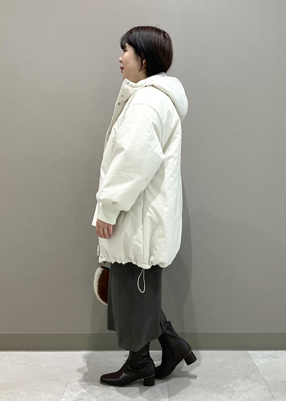 ホワイト系のニット/セーター、ブラウン系のショルダーバッグ、ブラウン系のスカートを着用したレディースの秋コーディネートの3枚目の写真