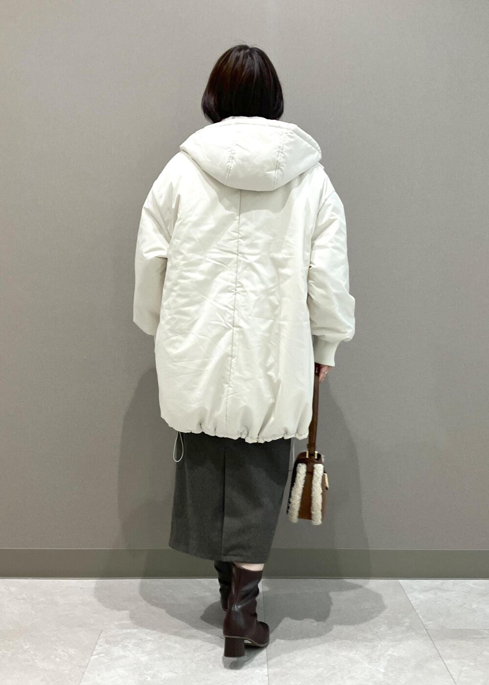 ホワイト系のニット/セーター、ブラウン系のショルダーバッグ、ブラウン系のスカートを着用したレディースの秋コーディネートの4枚目の写真