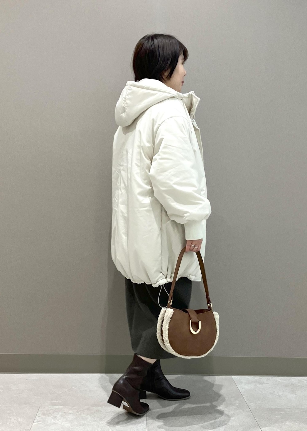 ホワイト系のニット/セーター、ブラウン系のショルダーバッグ、ブラウン系のスカートを着用したレディースの秋コーディネートの5枚目の写真