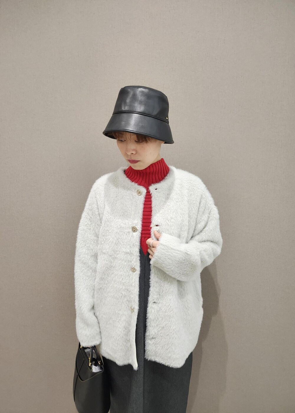 グレー系のジャンパースカート、ホワイト系のその他アウター、レッド系のニット/セーターを着用したレディースの秋コーディネートの7枚目の写真