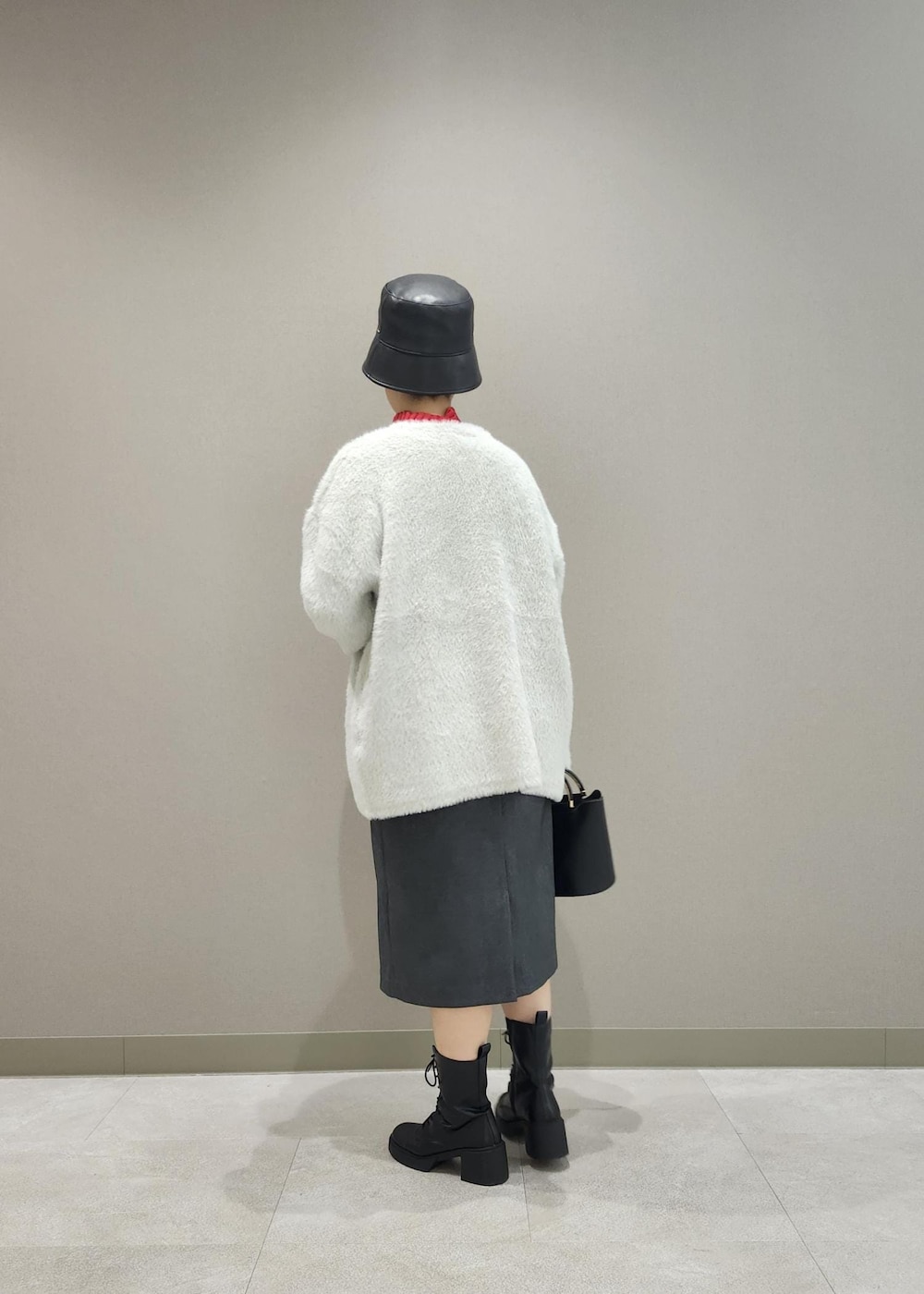 グレー系のジャンパースカート、ホワイト系のその他アウター、レッド系のニット/セーターを着用したレディースの秋コーディネートの5枚目の写真