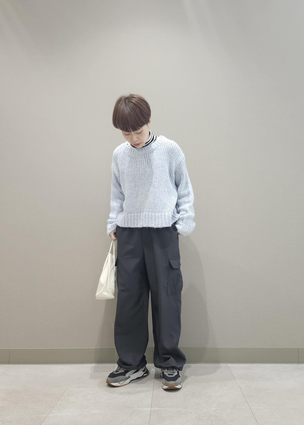 ホワイト系のニット/セーター、グレー系のカーゴパンツ、ブルー系のニット/セーターを着用したレディースの冬コーディネートの4枚目の写真
