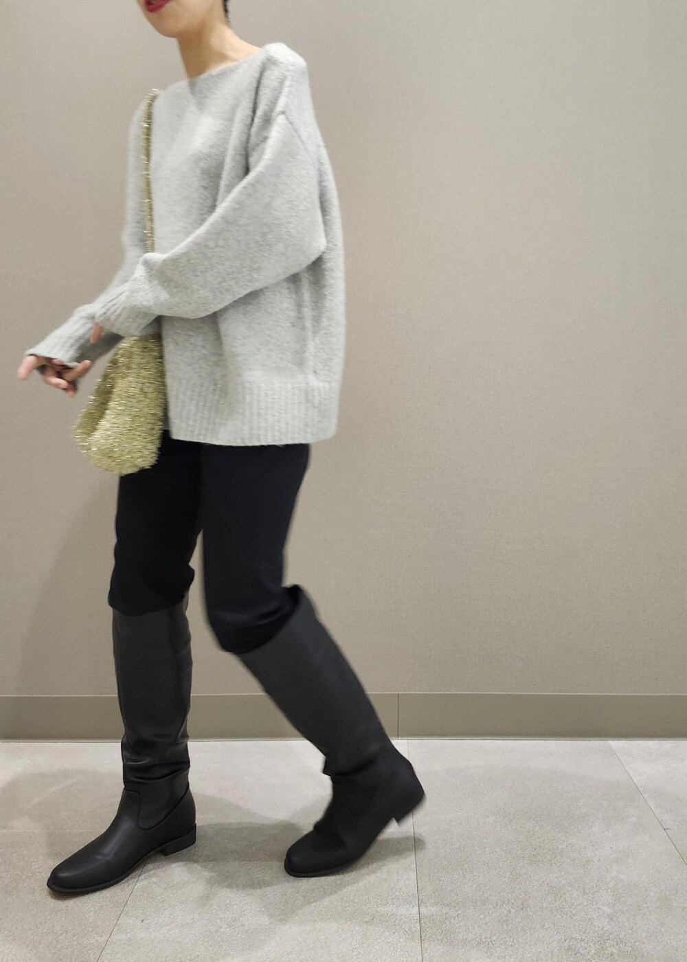 ブラック系のブーツ、ゴールド系のショルダーバッグ、グレー系のニット/セーターを着用したレディースの秋コーディネートの10枚目の写真