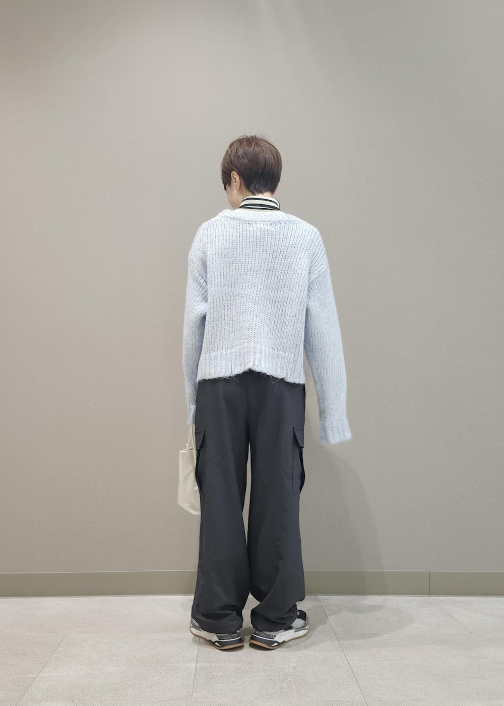 ホワイト系のニット/セーター、グレー系のカーゴパンツ、ブルー系のニット/セーターを着用したレディースの冬コーディネートの3枚目の写真