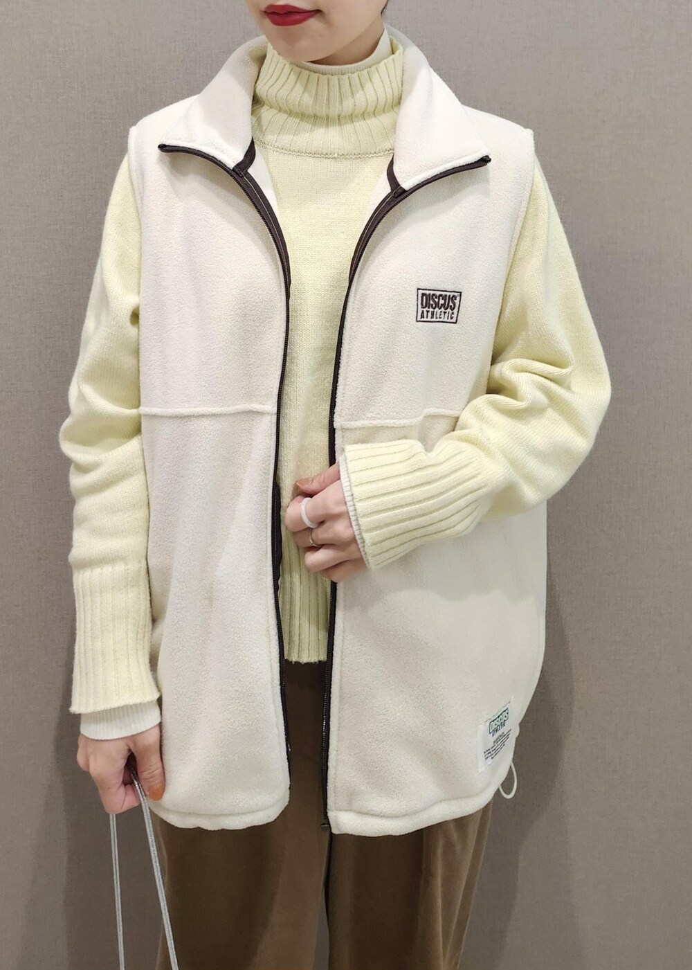 ホワイト系のニット/セーター、シルバー系のショルダーバッグ、ホワイト系のその他アウターを着用したレディースの冬コーディネートの7枚目の写真