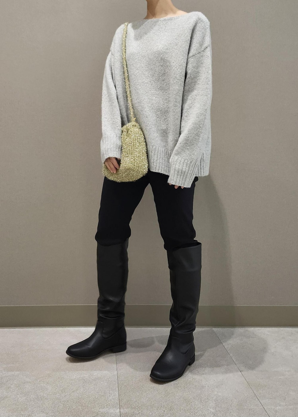 ブラック系のブーツ、ゴールド系のショルダーバッグ、グレー系のニット/セーターを着用したレディースの秋コーディネートの7枚目の写真