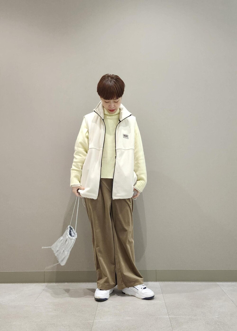 ホワイト系のニット/セーター、シルバー系のショルダーバッグ、ホワイト系のその他アウターを着用したレディースの冬コーディネートの2枚目の写真