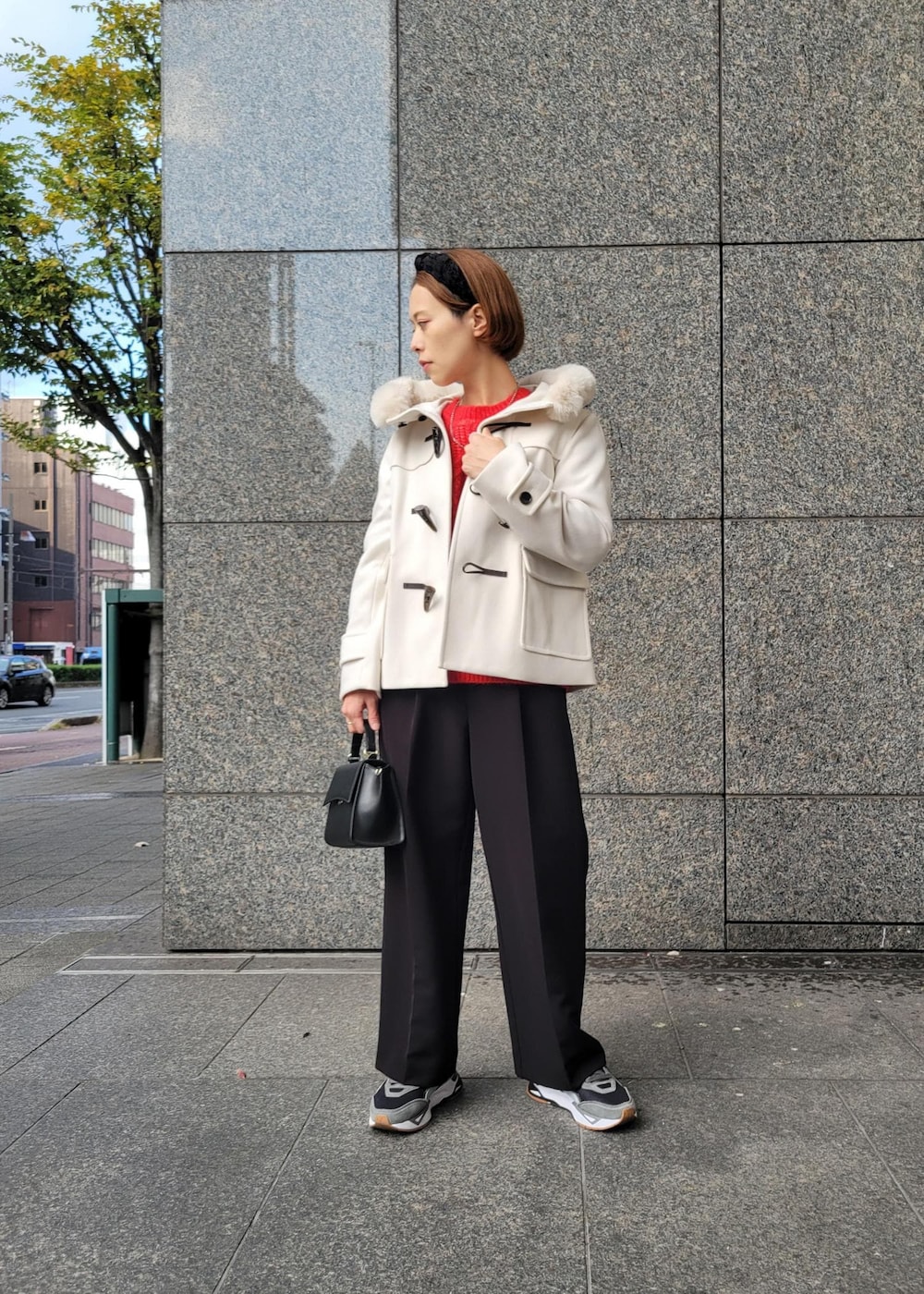 レッド系のニット/セーター、ブラック系のショルダーバッグ、ホワイト系のダッフルコートを着用したレディースの秋コーディネートの4枚目の写真