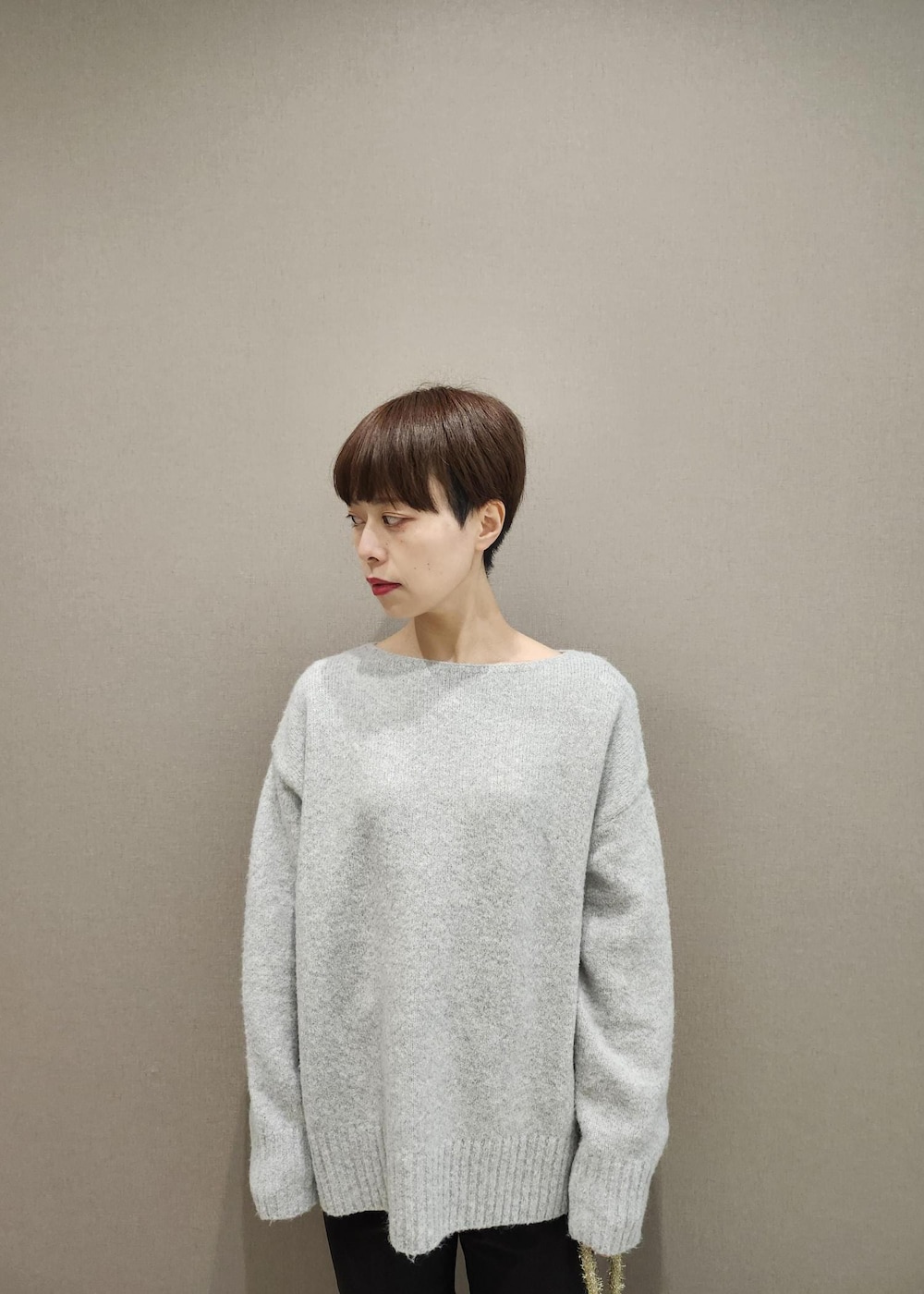 ブラック系のブーツ、ゴールド系のショルダーバッグ、グレー系のニット/セーターを着用したレディースの秋コーディネートの6枚目の写真