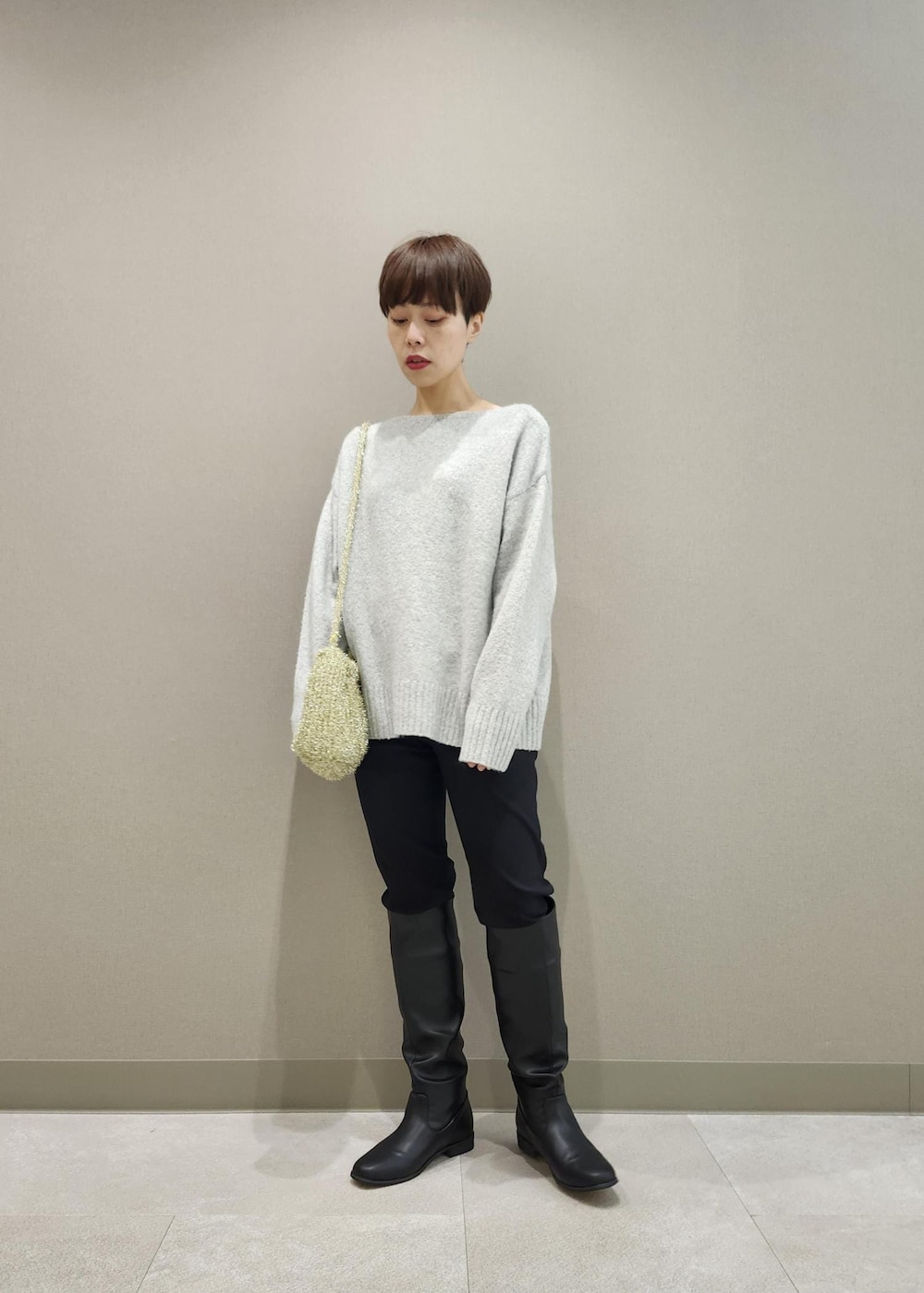 ブラック系のブーツ、ゴールド系のショルダーバッグ、グレー系のニット/セーターを着用したレディースの秋コーディネートの5枚目の写真