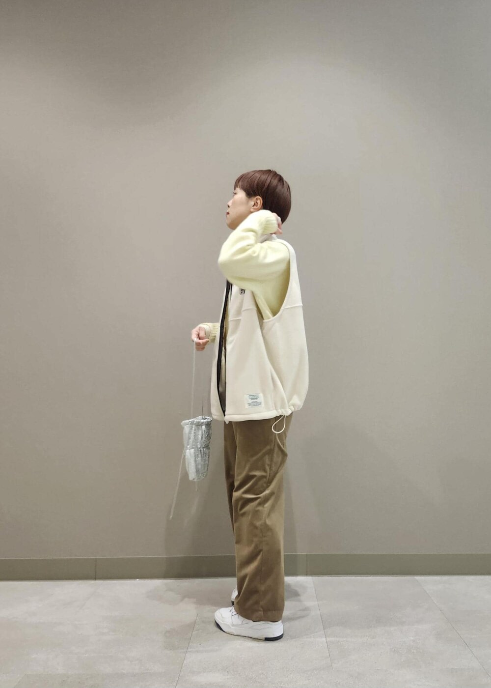 ホワイト系のニット/セーター、シルバー系のショルダーバッグ、ホワイト系のその他アウターを着用したレディースの冬コーディネートの5枚目の写真