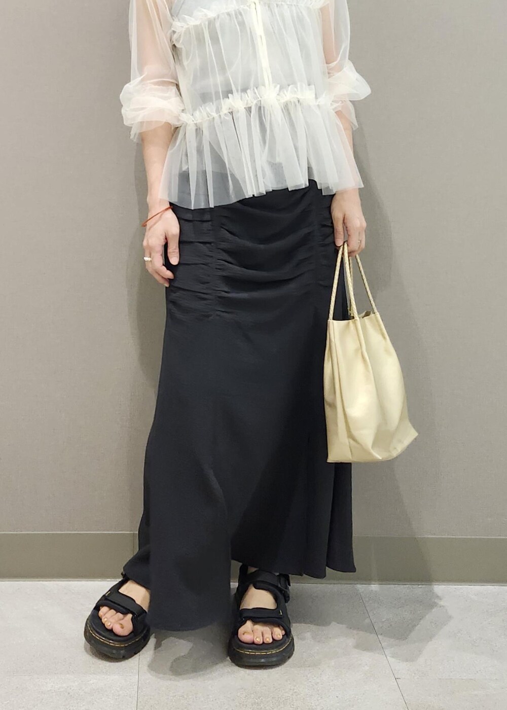 グレー系のタンクトップ、ホワイト系のカーディガン/ボレロ、ゴールド系のトートバッグを着用したレディースの夏コーディネートの8枚目の写真