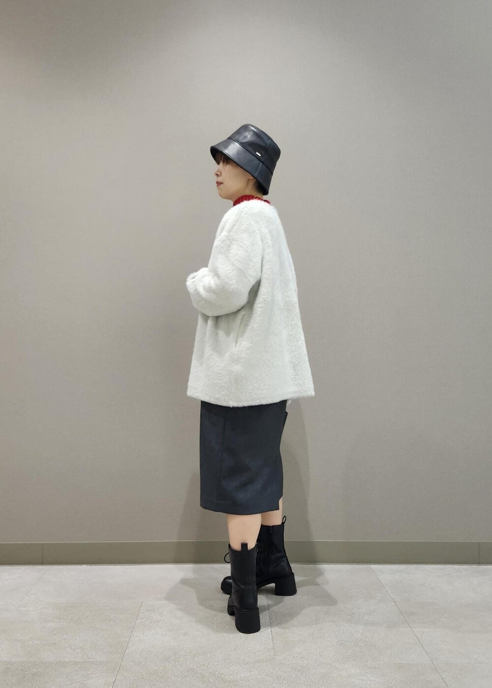 グレー系のジャンパースカート、ホワイト系のその他アウター、レッド系のニット/セーターを着用したレディースの秋コーディネートの3枚目の写真