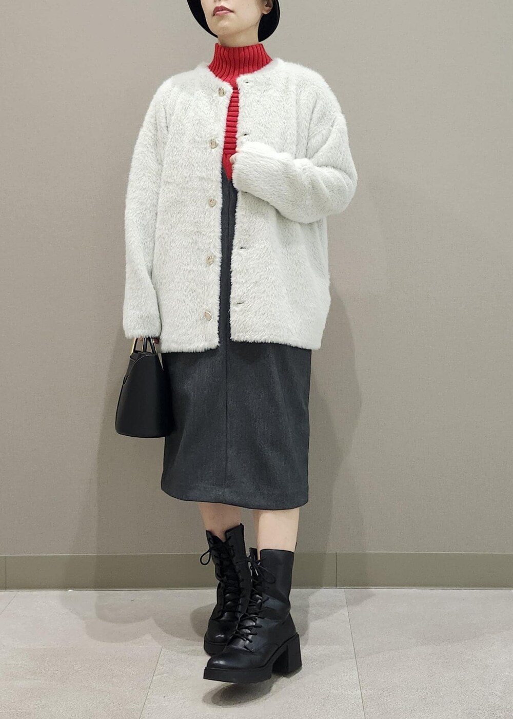 グレー系のジャンパースカート、ホワイト系のその他アウター、レッド系のニット/セーターを着用したレディースの秋コーディネートの6枚目の写真