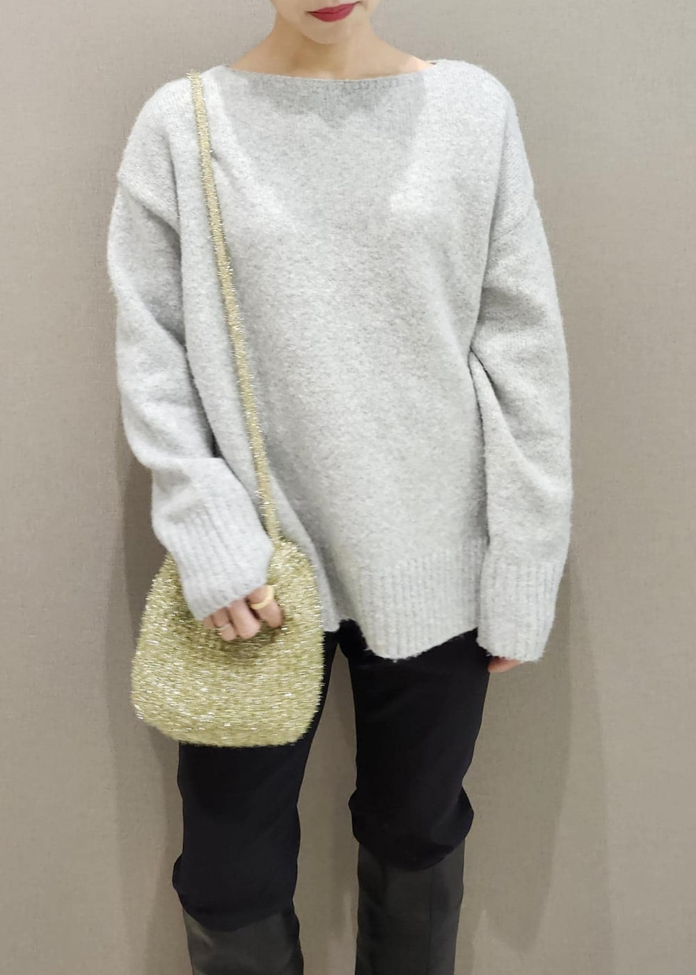 ブラック系のブーツ、ゴールド系のショルダーバッグ、グレー系のニット/セーターを着用したレディースの秋コーディネートの8枚目の写真