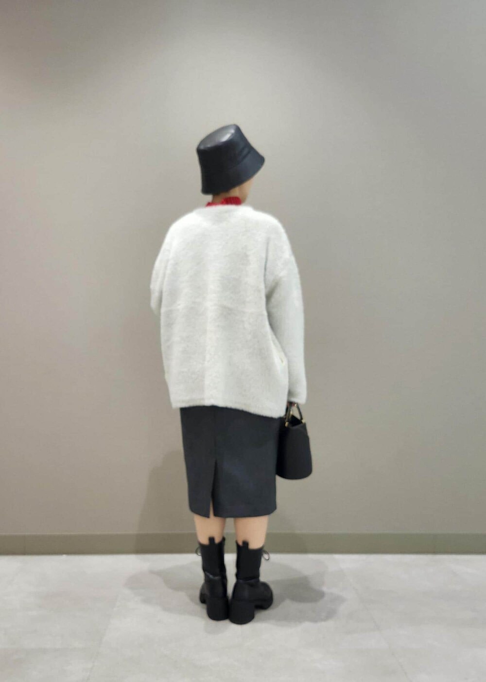 グレー系のジャンパースカート、ホワイト系のその他アウター、レッド系のニット/セーターを着用したレディースの秋コーディネートの4枚目の写真