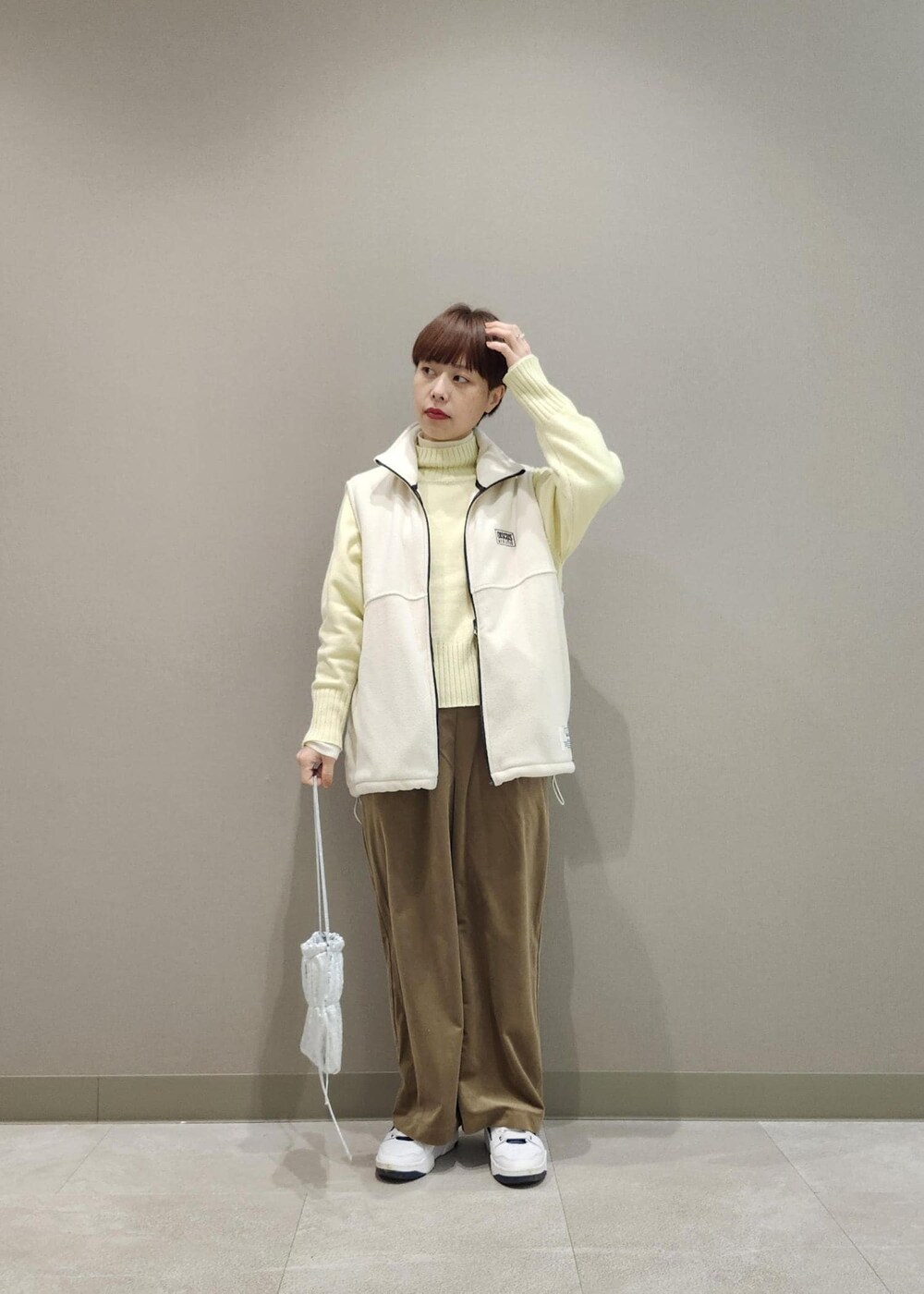 ホワイト系のニット/セーター、シルバー系のショルダーバッグ、ホワイト系のその他アウターを着用したレディースの冬コーディネートの3枚目の写真