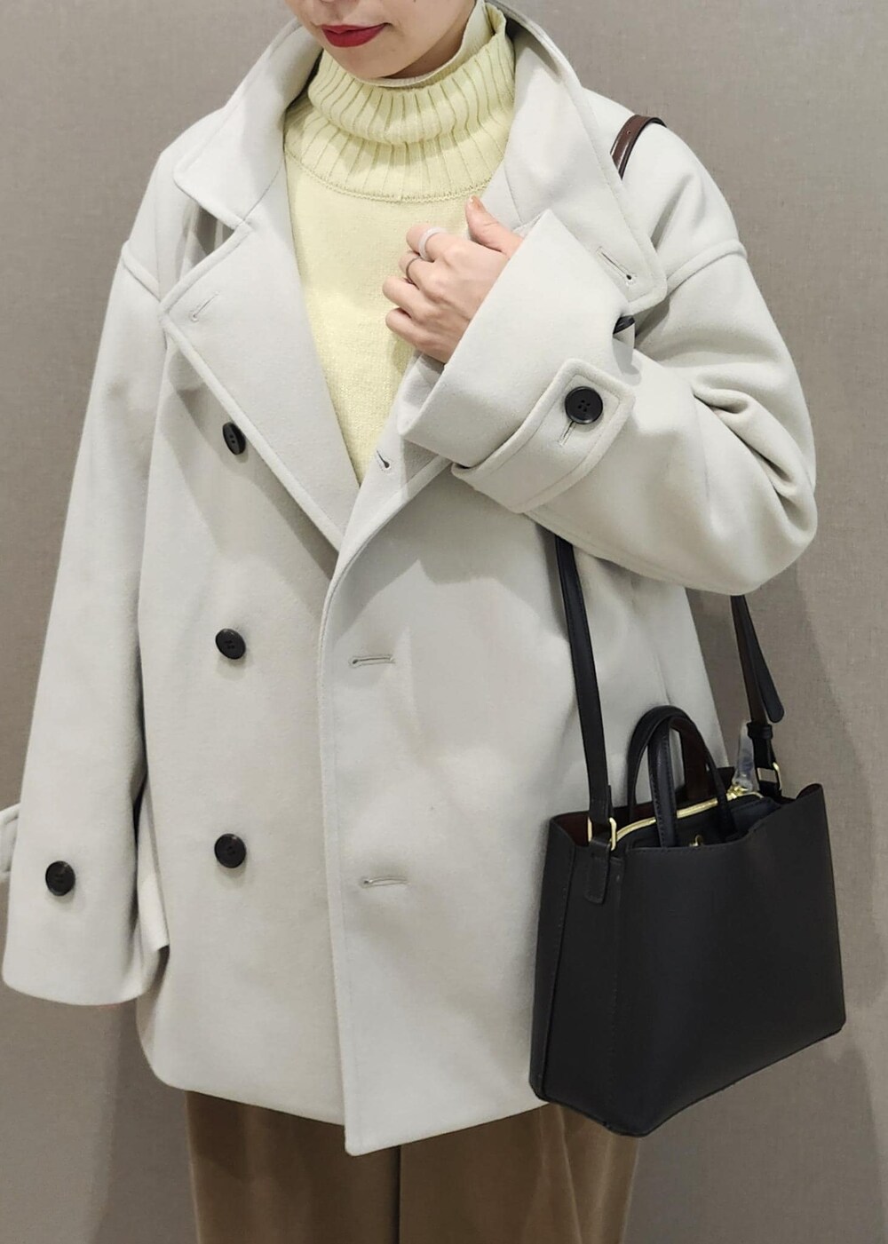 イエロー系のニット/セーター、ホワイト系のニット/セーター、ブラウン系のその他パンツを着用したレディースの冬コーディネートの6枚目の写真