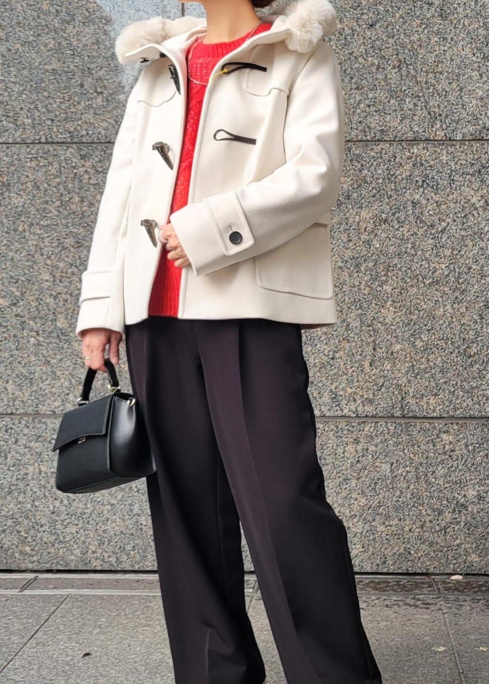 レッド系のニット/セーター、ブラック系のショルダーバッグ、ホワイト系のダッフルコートを着用したレディースの秋コーディネートの2枚目の写真